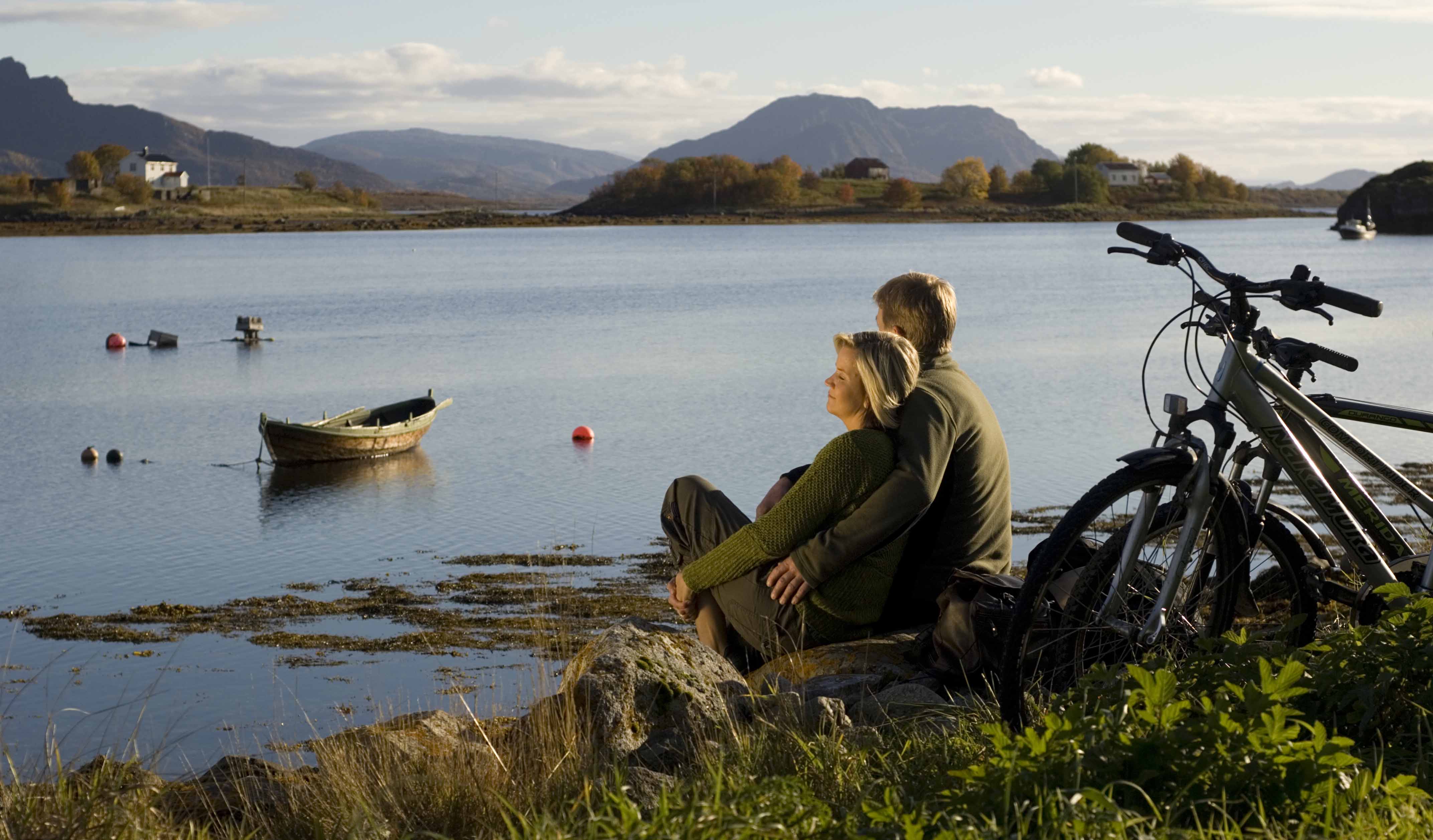 A couple on a biketrip relaxing by the shore, Brønnøysund.