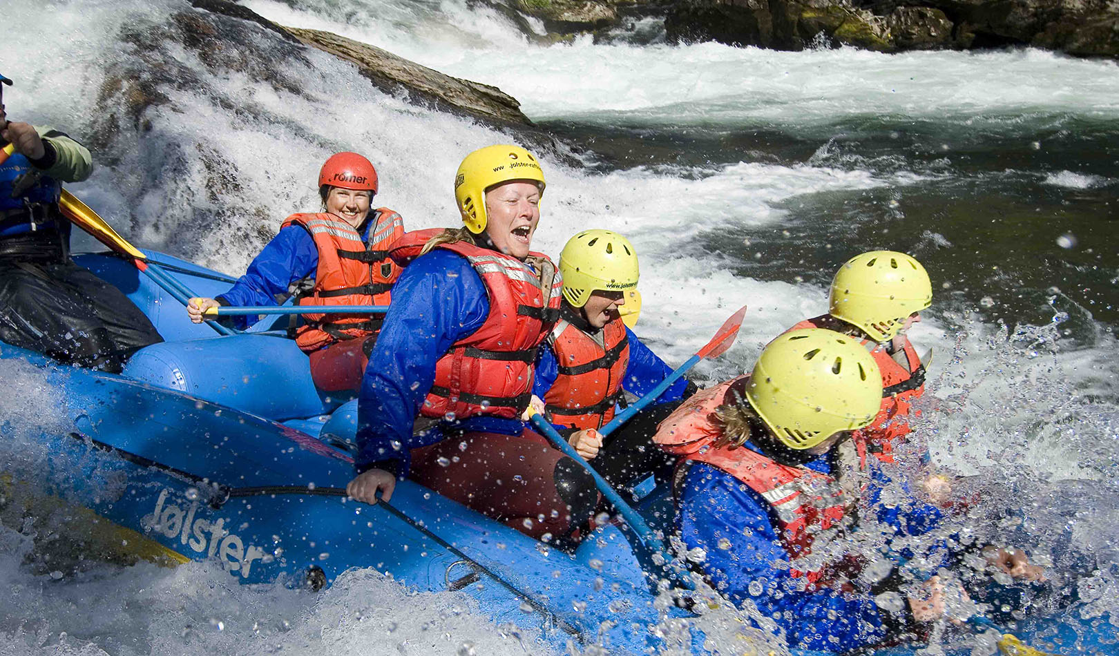 En gruppe mennesker på elverafting nedover Jølstra i en gummibåt.