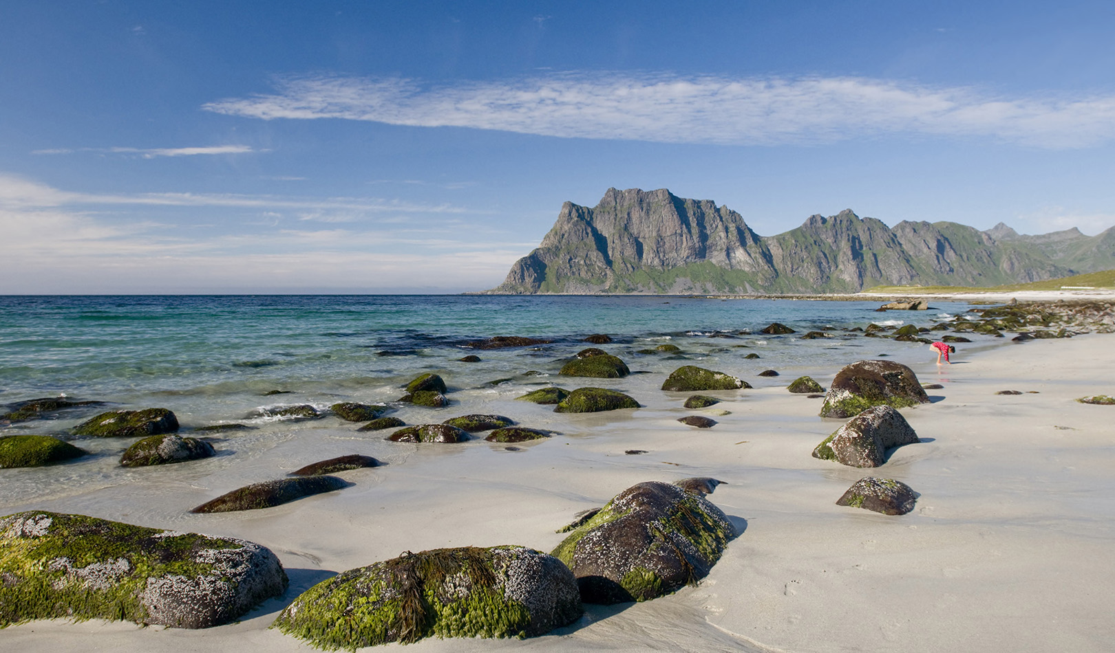 Beach with big rocks, ocean and mountains in Utakleiv, Lofoten.