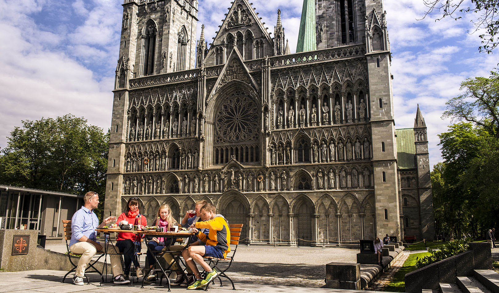 Family eating luch outside Nidarosdomen cathedral in Trondheim.