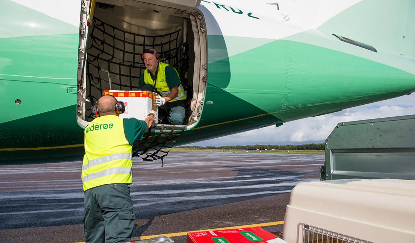 Flyfrakt og bagasje bæres ut av fly av Widerøes flyplassansatte.