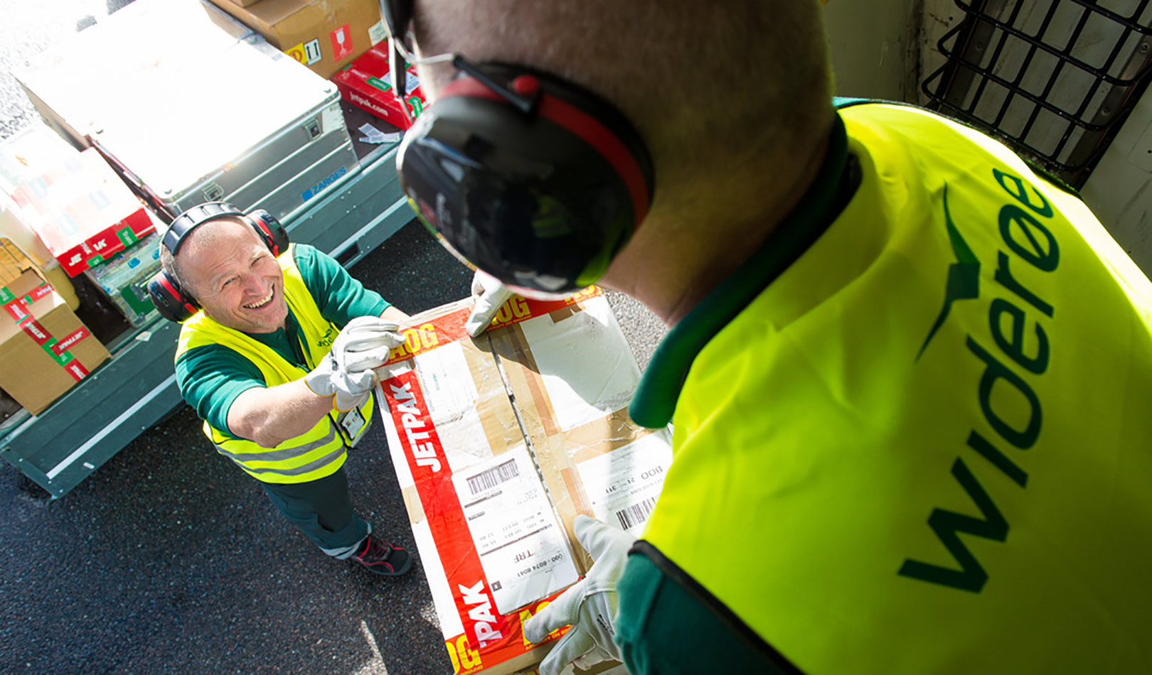 Flyfrakt overleveres mellom Widerøes flyplasspersjonell.