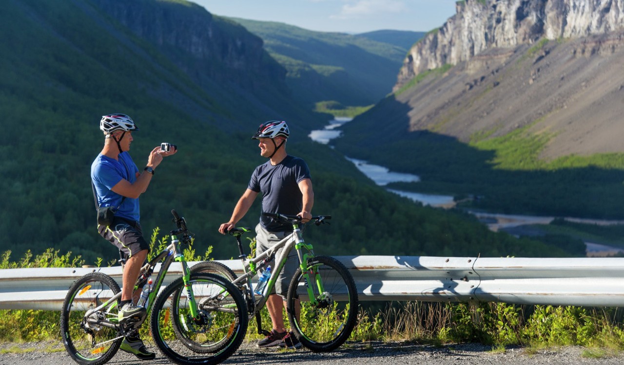 To syklister tar en pause og filmer hverandre i Finnmark. Two cyclists taking a break and filming each other i Finnmark. 