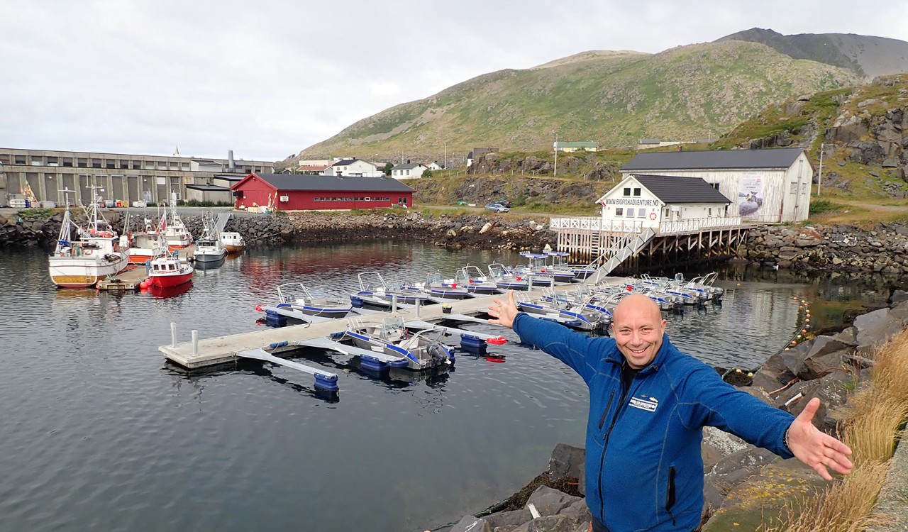 Mann viser frem anlegget til Big Fish Adventure I Hasvik på Sørøya, Finnmark. Man shows off the docks of Big Fish Adventure site in Hasvik, Sørøya, Finnmark.