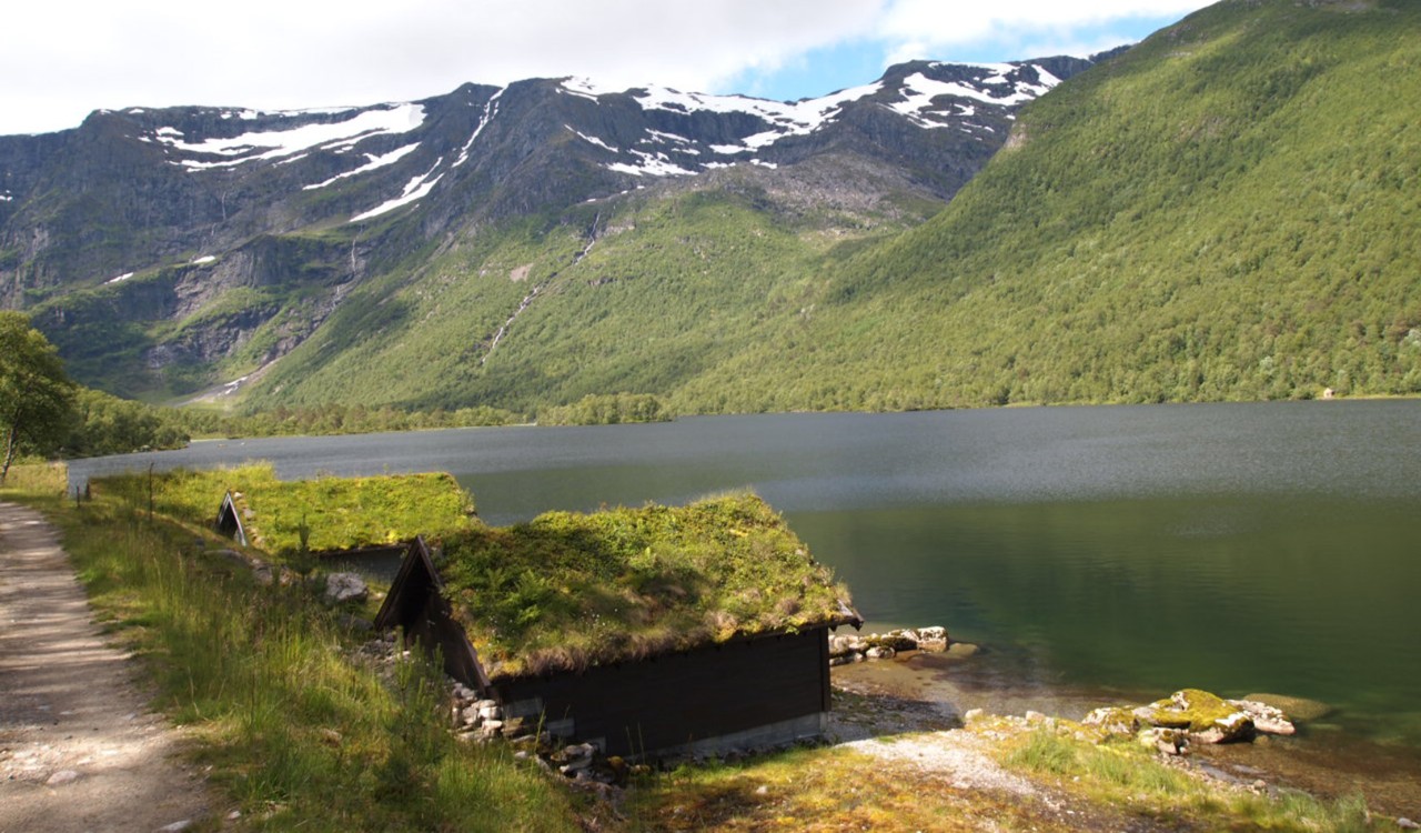 Hytter med torvtak ved vannet i Traudalen, Gloppen. Cabins by the water in Traudalen, Gloppen.