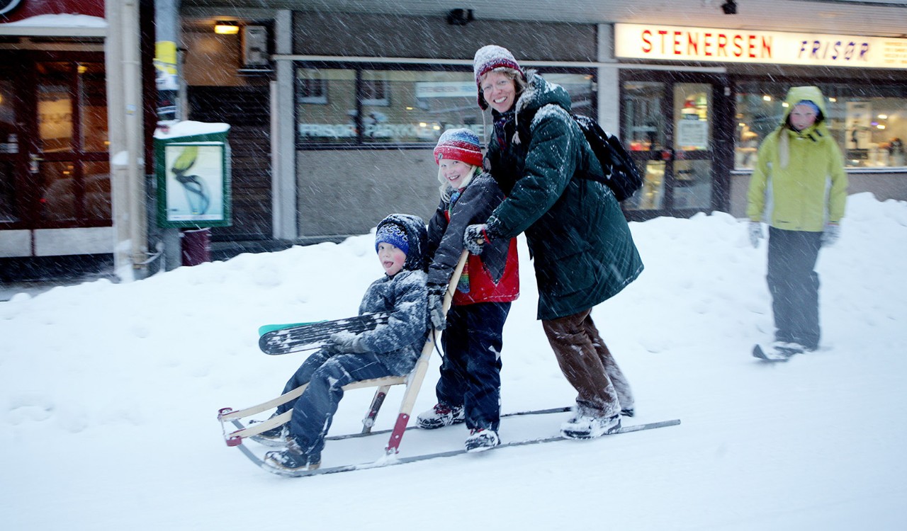 Familie på spark i Tromsø sentrum. Family on a "spark", an typical Norwegian kind of vehicle you use in the snow. 