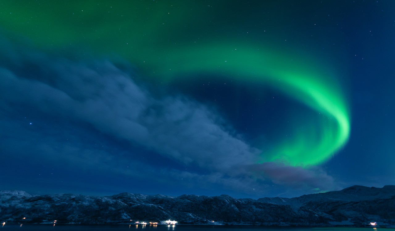 Dramatisk nordlys over mørk himmel i Tromsø. Dramatic northern light over dark sky in Tromsø.