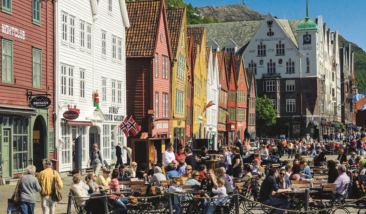 Folkeliv på Bryggen i Bergen en solskinnsdag. People eating and drinking at Bryggen in Bergen a sunny day.