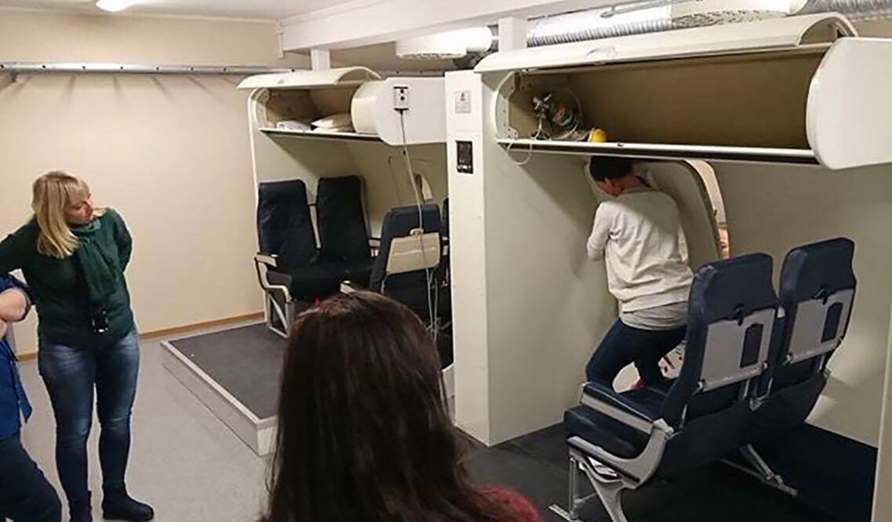 Deltakere I en flysimulator på kabinkurs hos Widerøe. Participants on a cabin safety course conducted by Widerøe.