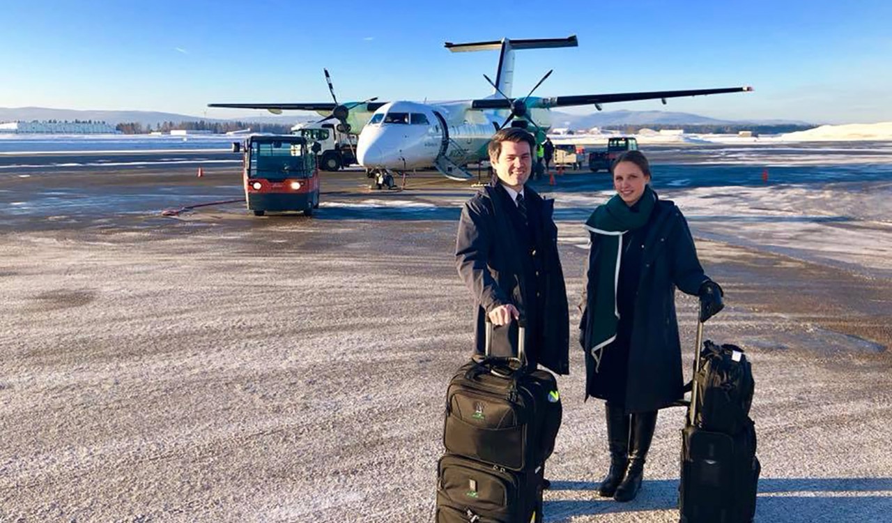 Widerøe kabinansatte Steinar og Kristina i ferd med å gå ombord et fly. Widerøe employees Steinar and Kristina at work entering an Widerøe aircraft.