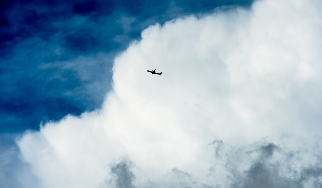 Fly i silhuett mot store skyer. Plane in silhouette against big clouds. 