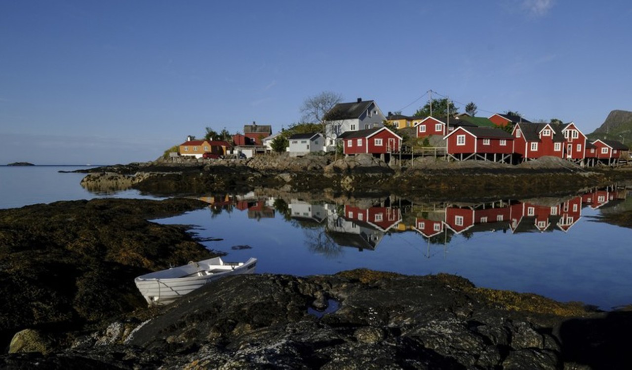 Røde rorbuer ved sjøkanten. Red little cabins by the sea.