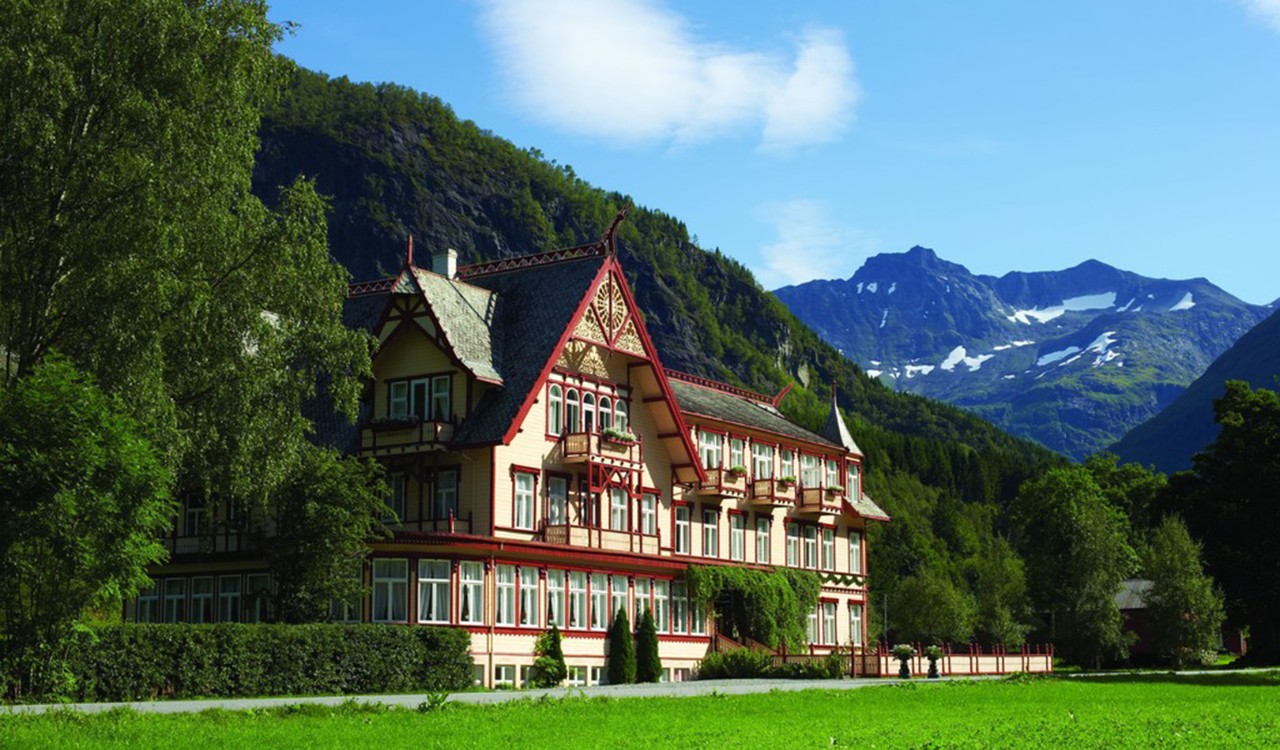 Eksteriør av Union Hotel på Øye i Norangsdalen med fjell i bakgrunnen. Exterior of old hotel in Norangsdalen with mountains in the background. 