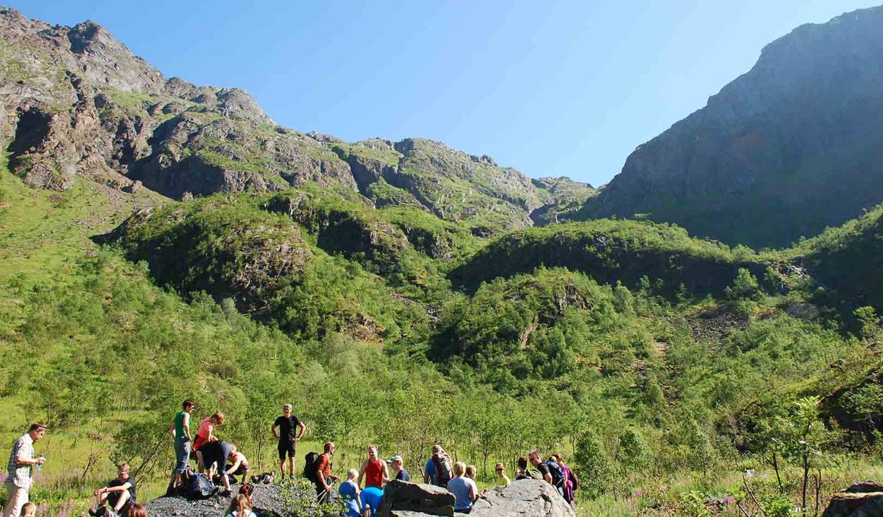 Folk og fjellfører tar en pause på vei opp Møysalen, Vesterålen. People relaxing on a guidet tour to the mountain of Møysalen, Vesterålen.