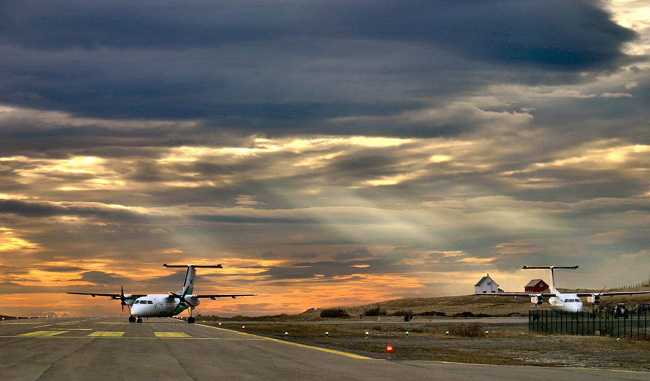 Fly kommer inn på rullebanen med dramatisk himmel over. Plane taxing on to the runway with dramatic sky above.