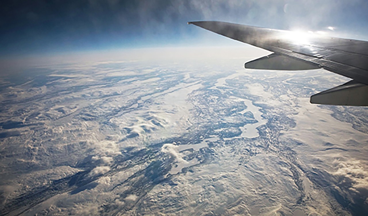 Flyvinge over snølandskap. Plane wing over snowy landscape.