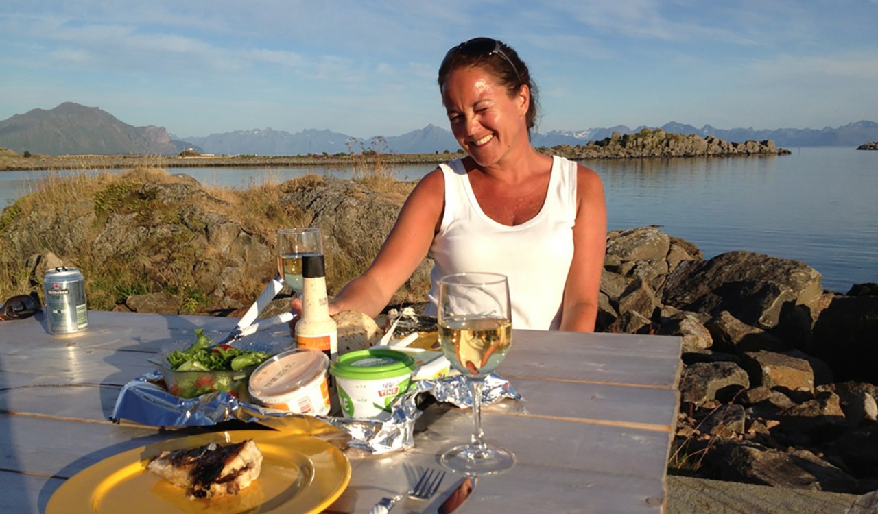 Sissel nyter et glass hvitvin på Skagakaia I Bø I Vesterålen. Sissel enjoying food and a glass of wine on the docks in Bø, Vesterålen.